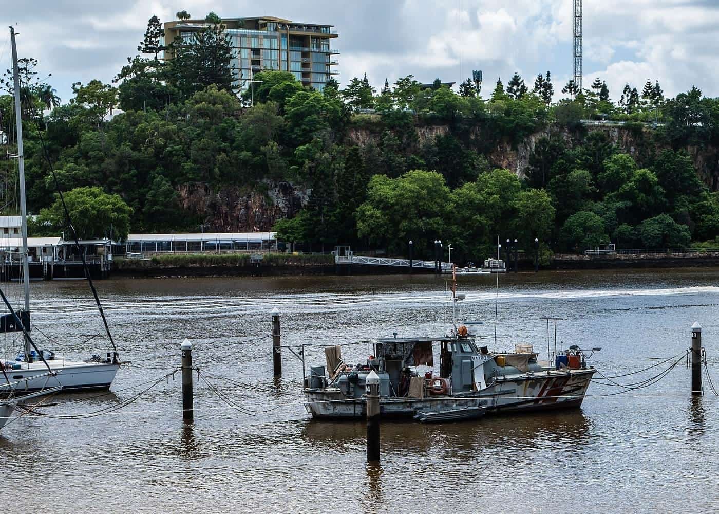 Yachts moored at piles and pontoons on a city river