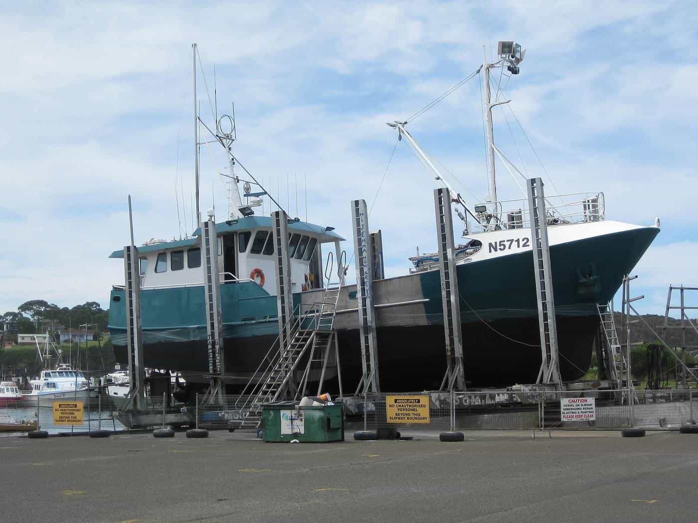 A fishing boat hauled out on stands on a boatyard hardstand