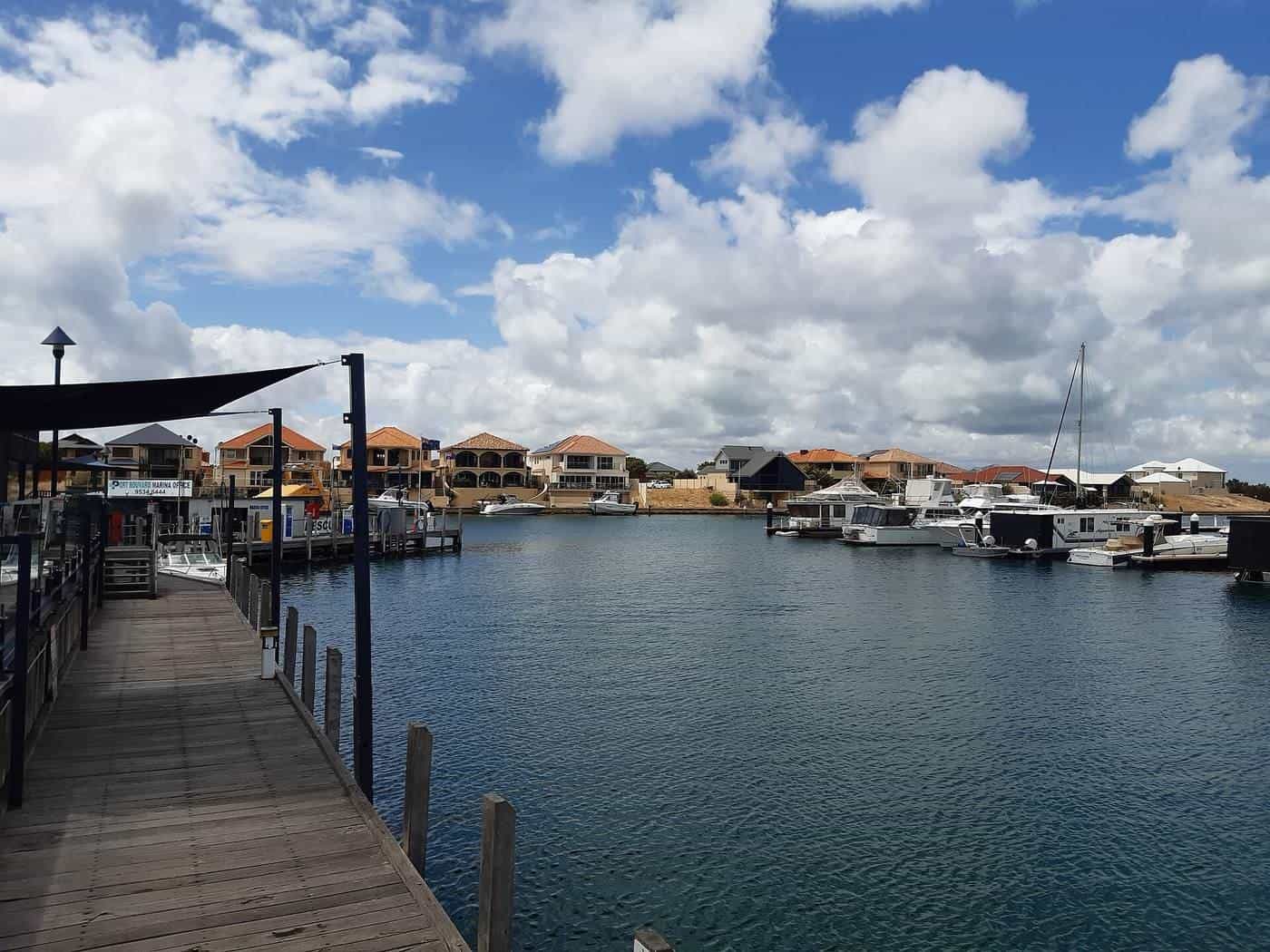 A modern marina with pontoons and moored boats under blue sky in Western Australia