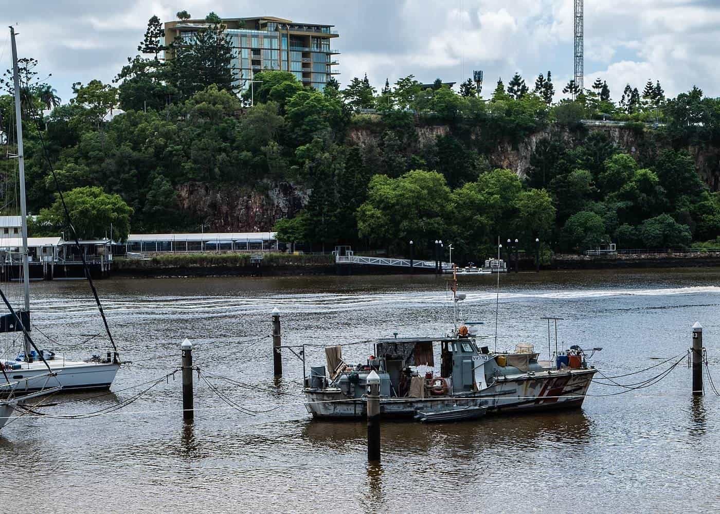 Yachts moored at piles and pontoons on a city river